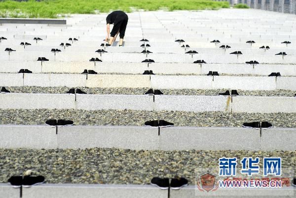 8月14日,一名青年将布鞋整齐地摆放在广场上。 新华社发 8月14日,一名青年将布鞋整齐地摆放在广场上。 新华社发